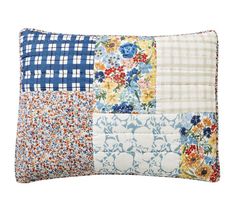 a blue and white patchwork pillow with flowers on it