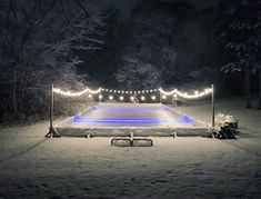 an ice rink is lit up at night in the snow with christmas lights on it