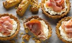 small appetizers are arranged on a sheet of parchment paper with bacon and cream cheese