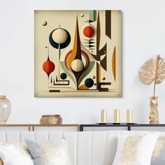 an abstract painting hangs on the wall above a white couch with pillows and vases