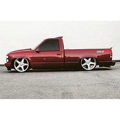 a red truck parked in front of a white wall