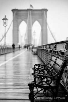 a bench sitting on the side of a bridge