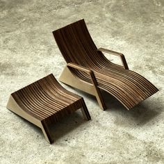 two wooden lounge chairs sitting next to each other on a cement floor, one is shaped like a reclining chair