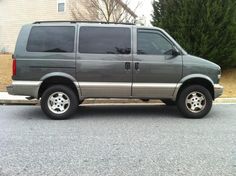 a gray van parked in front of a house