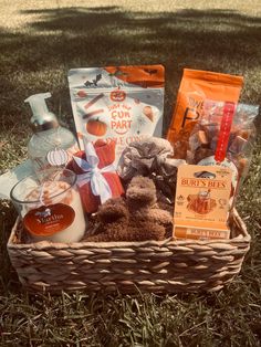 a basket filled with treats and drinks on the grass