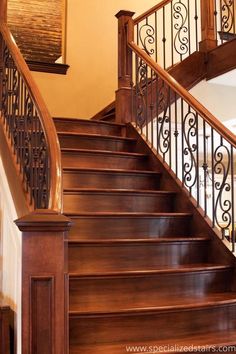 a wooden staircase with wrought iron handrails