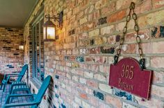 a brick wall with blue chairs and a sign that reads 350 broadway on it's side