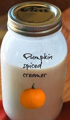 a pumpkin spiced creamer sitting on top of a wooden table next to a jar