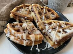 some waffles with icing on a black plate