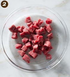 raw meat cubes in a glass bowl on a marble countertop with text overlay