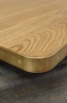 a close up of a wooden table top with metal trim on the bottom and sides