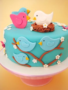 a blue cake decorated with birds and flowers