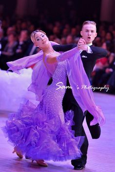 a man and woman in ballroom clothes dancing