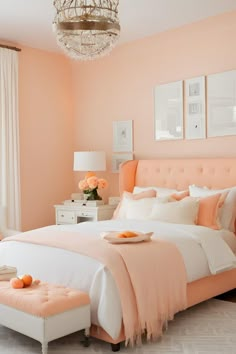 a bedroom with peach colored walls and white bedding, chandelier above the bed