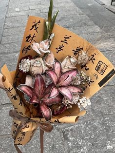 a bouquet of flowers is wrapped in brown paper