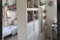 a room with white walls and shelves filled with books