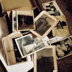 many old photos are laying on top of each other in an open box with paper