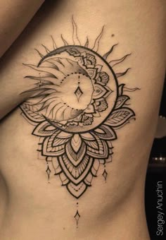 a woman's stomach with a sun and moon tattoo on the side of her body