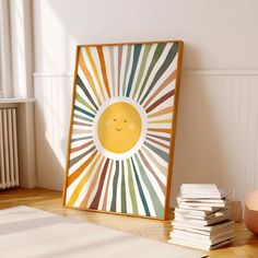 a wooden frame with a smiley face on it in front of a stack of books