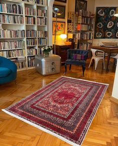 a living room filled with furniture and bookshelves full of bookcases next to a blue chair