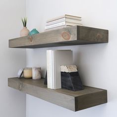 two wooden shelves with books and vases on them