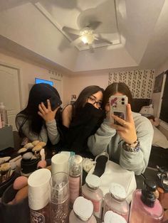 two young women taking a selfie in front of their makeup and personal care products