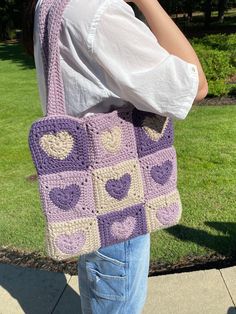 a woman carrying a crocheted bag on her shoulder