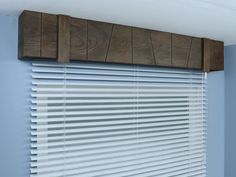 a window with wooden slats on the top and bottom, in a blue room