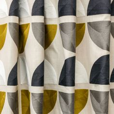 a curtain with an abstract design in grey, yellow and white colors on it's side