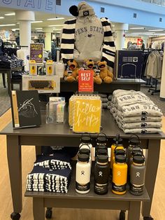 a display in a store filled with clothing and other items on a wooden table next to a stuffed animal