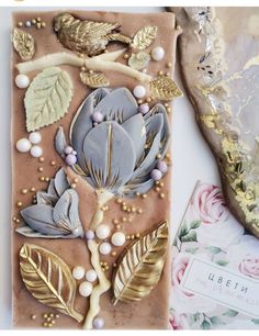 a close up of a cake with flowers and leaves on it