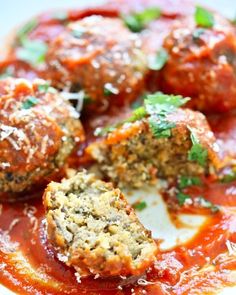 meatballs in marinara sauce with parmesan cheese and herbs on the side