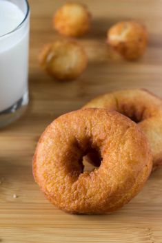 two doughnuts and a glass of milk on a table