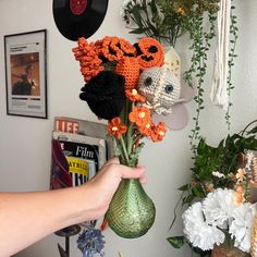 a person holding a vase with flowers in it next to a wall mounted record player