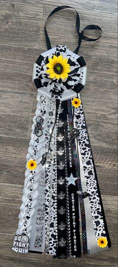 a black and white dress with sunflowers on the front, ribbon in the back