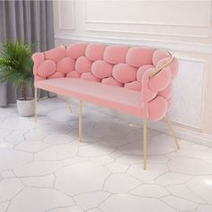 a pink couch sitting on top of a white floor next to a potted plant