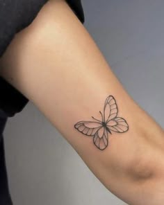 a woman's arm with a small butterfly tattoo on the left side of her arm