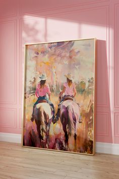 two women riding horses in front of a pink wall with wood flooring and large painting on the wall