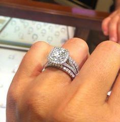 a close up of a person's hand with a diamond ring