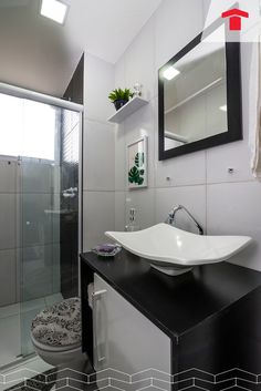 a white sink sitting under a bathroom mirror next to a walk in shower and toilet