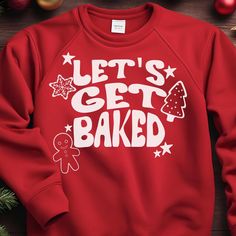 a red sweatshirt with the words let's get baked on it next to christmas decorations