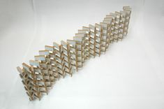 a sculpture made out of wooden sticks on a white surface