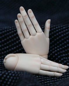 a white plastic hand sitting on top of a black cloth