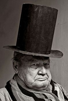 an old man wearing a top hat and scarf