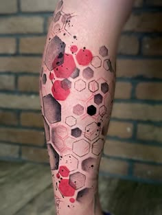 a man's leg with red and black ink on it, showing hexagonals