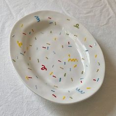 a white plate with sprinkles and numbers on the rim is sitting on a table