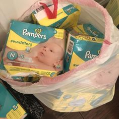 a basket filled with diapers and wipes on top of a wooden floor next to a wall