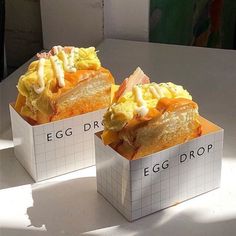 two boxes with eggs in them sitting on a table