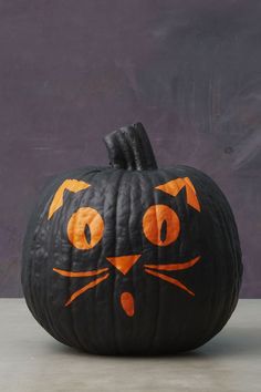 a pumpkin with an orange cat painted on it