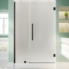 a bathroom with green walls and white tile flooring, including a walk in shower